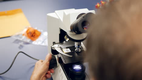 un técnico de laboratorio médico que examina las células cancerosas de la biopsia de un paciente para diagnosticar la enfermedad en un laboratorio de investigación