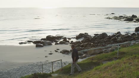 senior man walking beside the sea