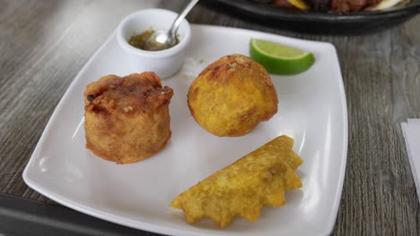 aborrajado, marranita and empanada served with spicy sausage. traditional colombian food. close up