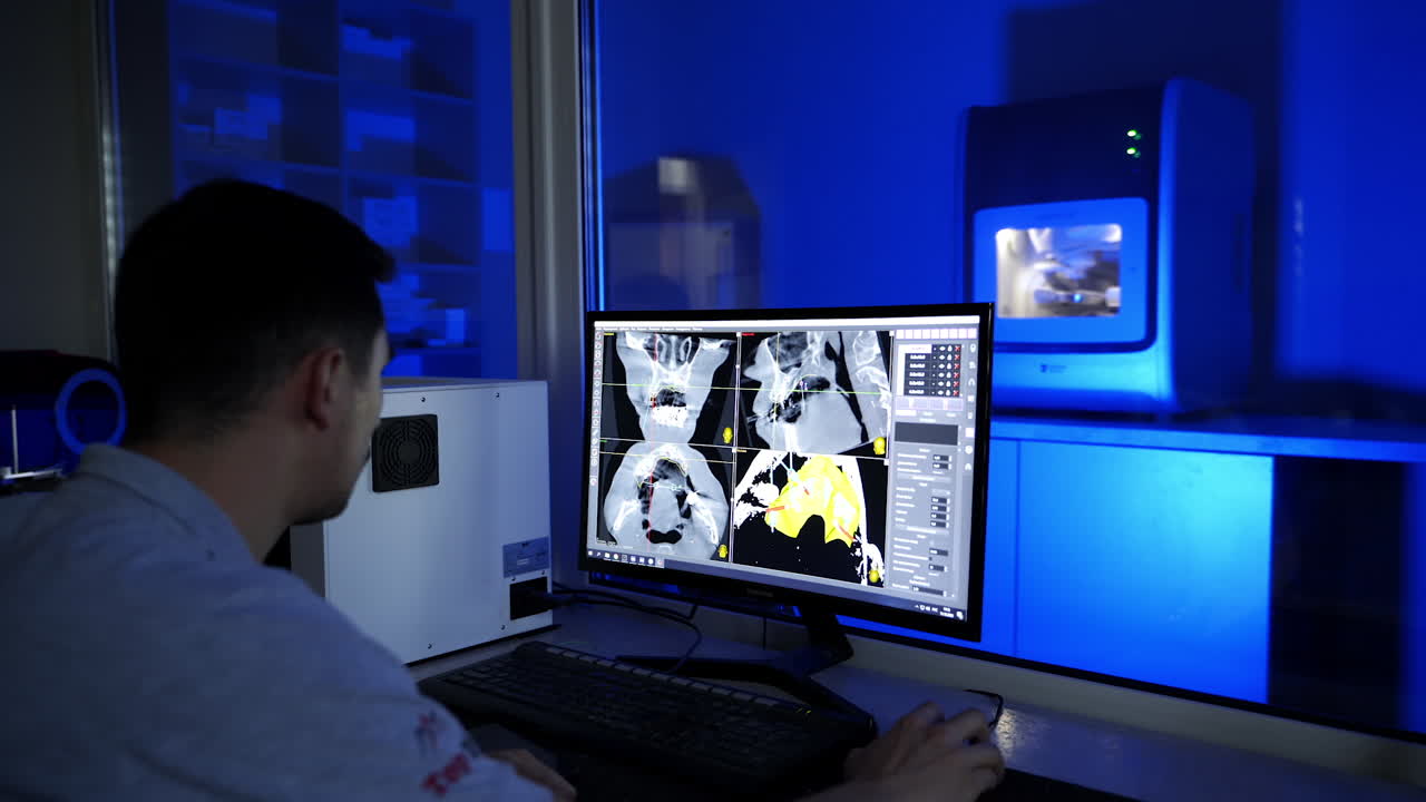 Dental technician in the clinic. Works of advanced automated dental milling machine producing crowns