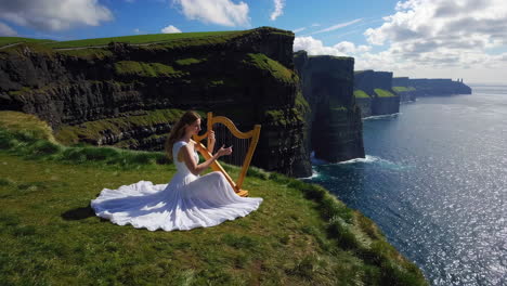 woman playing harp on the cliffs of moher, ireland