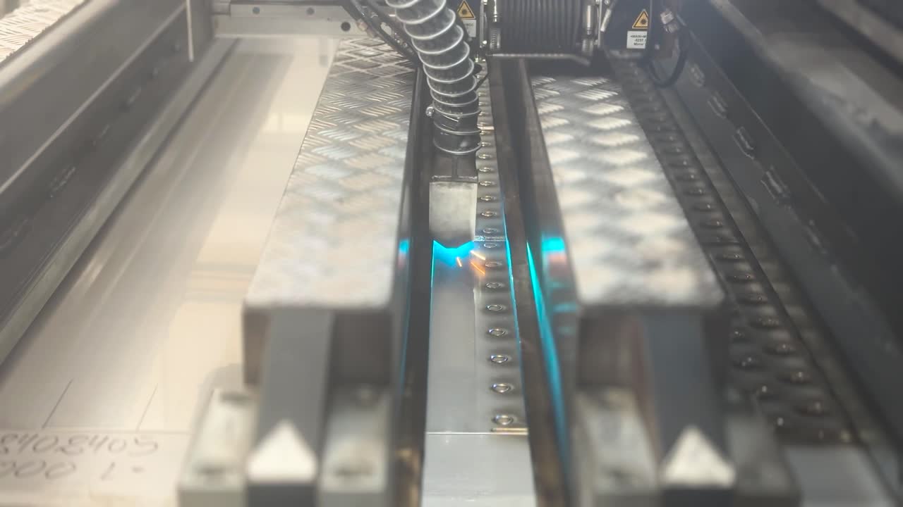 Industrial laser machine welding metal, a robotic mechanism in a factory. Technology concept. A flat sheet of stainless steel is being welded with flashes. Front view. Type C
