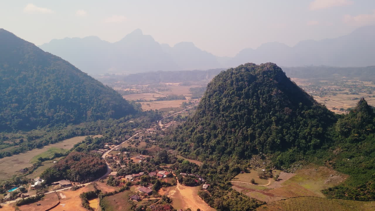 Vista aerea di una valle montuosa con un villaggio e risaie