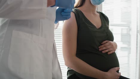 Arzt-Trägt-Direkt-Nach-Der-Impfung-Heftpflaster-Auf-Den-Arm-Einer-Schwangeren-Kaukasischen-Frau-Auf.