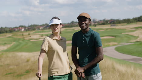 caucasian woman and african american man on the golf course.