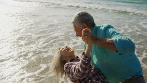 vista lateral de una pareja caucásica senior activa bailando juntos en la playa 4k