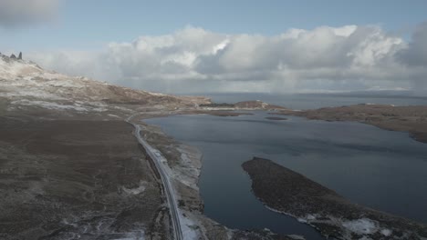 Die-Skye-Bridge-Und-Loch-Alsh-In-Den-Ruhigen-Schottischen-Highlands,-Mit-Vereinzeltem-Schnee-Und-Dynamischen-Wolken,-Luftaufnahme