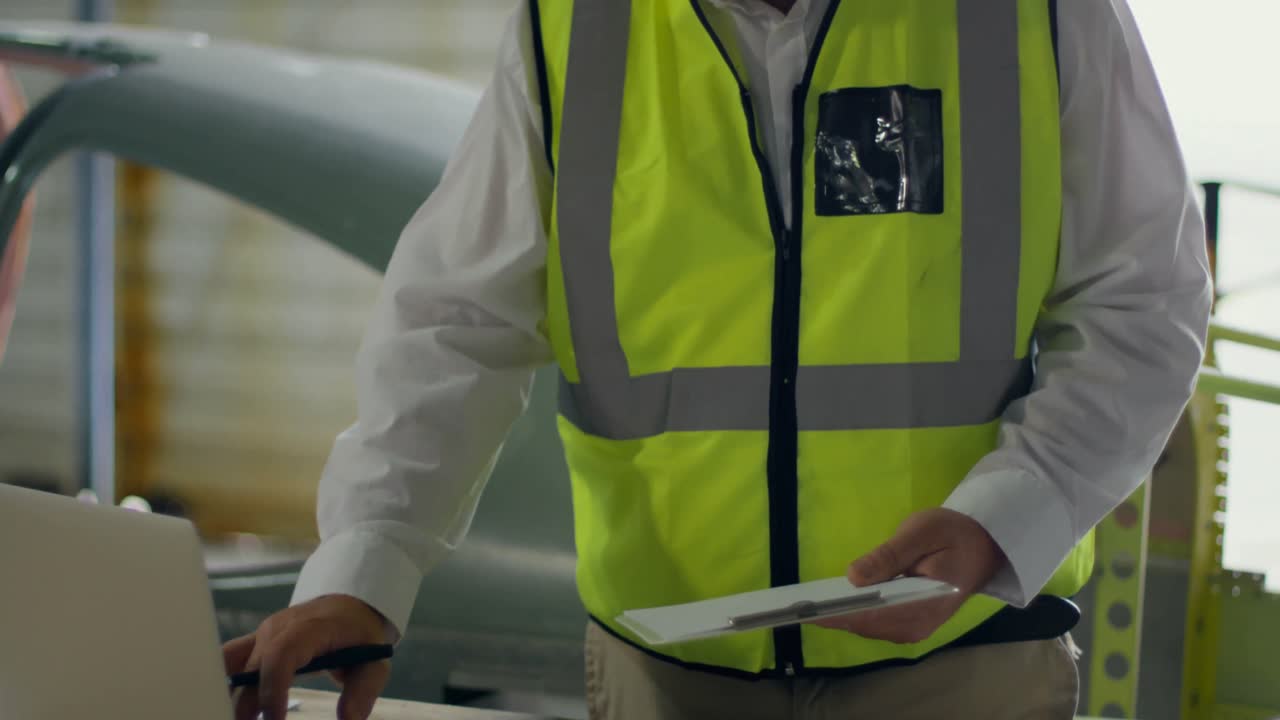 ingeniero masculino usando una computadora portátil mientras mira el portapapeles 4k