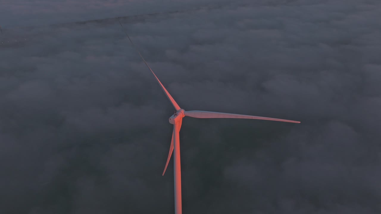 Parco eolico offshore all'Afsluitdijk che si illumina all'alba, producendo energia verde.