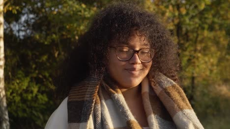smiling black woman with curly hair portrait video in autumn forest