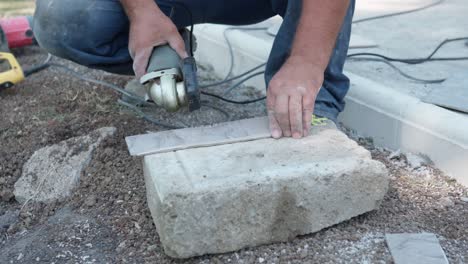 professional workman using electric grinder with sharp circular blade disc for cutting ceramic tile on construction site, builder without protective gloves cutting ceramic tile with grinder. dangerous