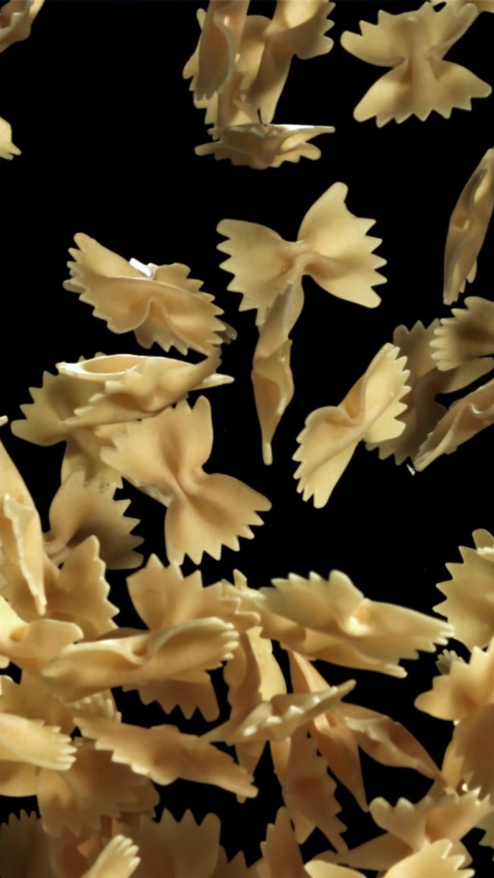 Pasta farfalle che cade al rallentatore su uno sfondo nero