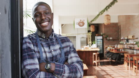 Portrait-of-happy-african-american-male-coffee-shop-owner-at-his-shop,-slow-motion