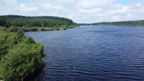 Idyllisches-Blaues-Wasserreservoir-See-Wald-Wanderweg-Luftaufnahme-Niedrige-Umlaufbahn-Links-Offenbaren-Ruhigen-Loch