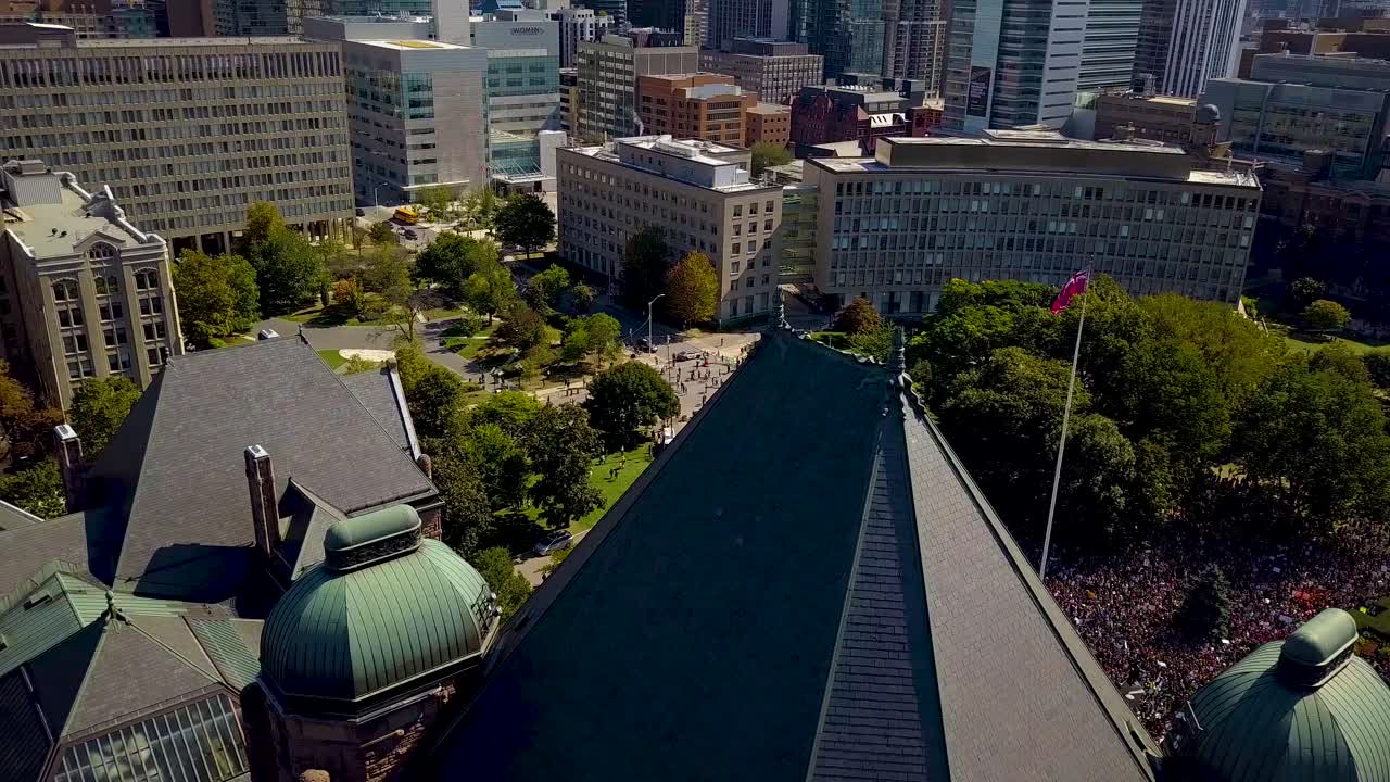 Aerial View of a City with a Large Crowd of People in a Park near University Buildings