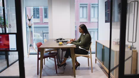 businesswoman working on laptop at desk in meeting room