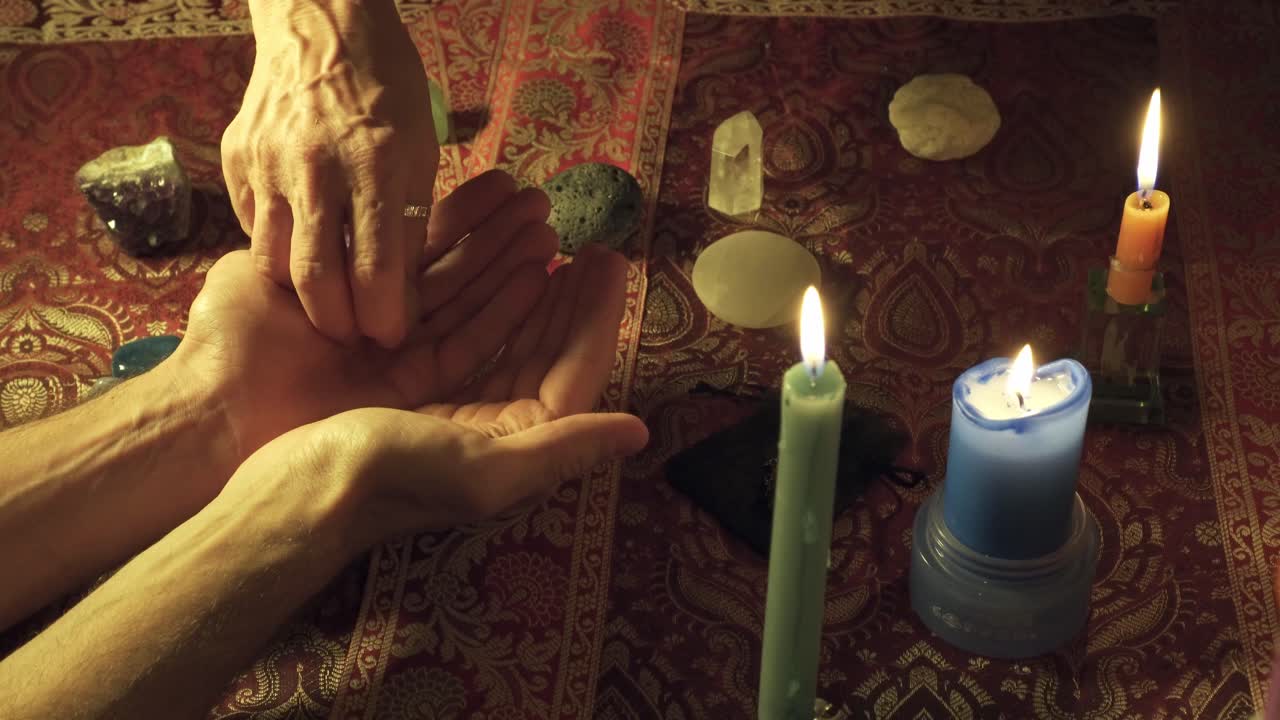 un primer plano de una bruja entregando una piedra de curación mágica a otra persona para curar la mente en un ritual místico