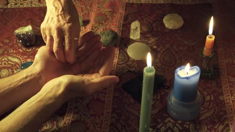 close-up shot of a witch handing a magical healing stone to another person to heal the mind in a mystical ritual