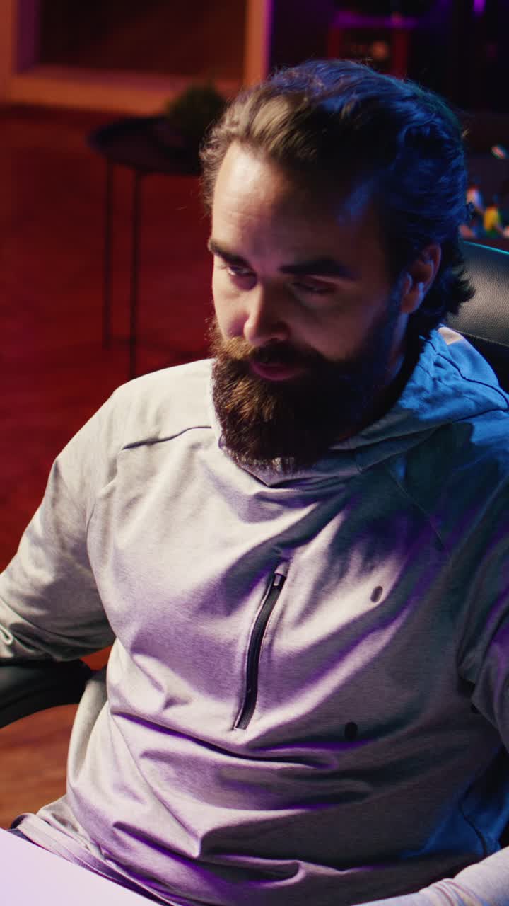 Vertical video Content creator streaming live from RGB lit living room, recording videogame guide for audience