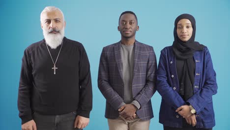 portrait of a mature christian man and african young muslim man and young woman in brotherhood and piety.