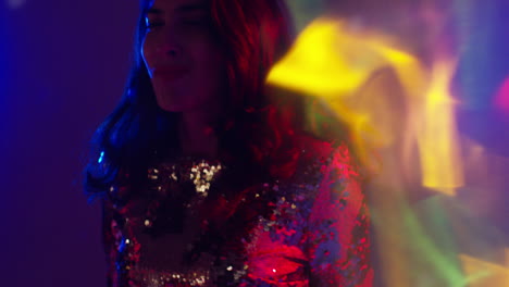 primer plano de una mujer en un bar nocturno o discoteca bailando con luces brillantes 7