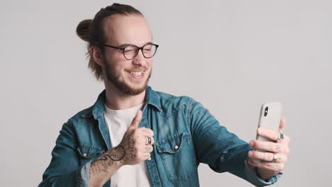 joven caucásico teniendo una llamada de video en el teléfono inteligente.