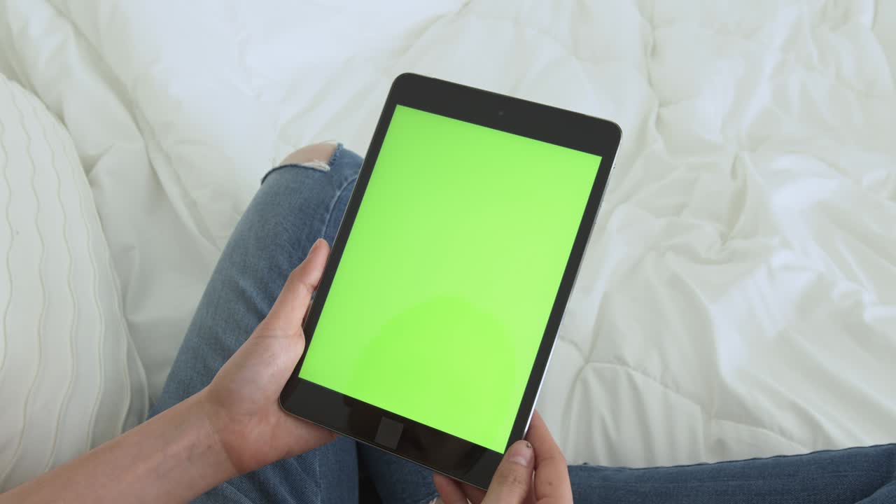 mujer sosteniendo una tableta digital con pantalla verde y dispositivo táctil navegando por internet.