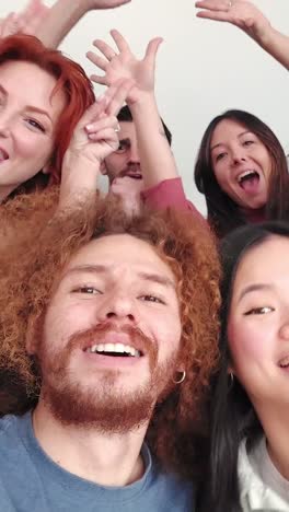 multiethnic friends joking taking a selfie together at home