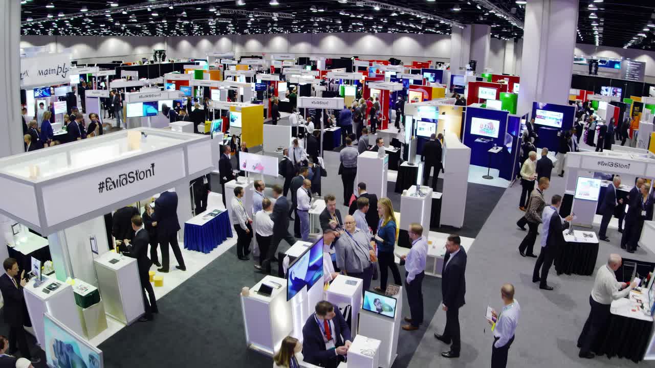Aerial view of a bustling trade show with numerous booths and attendees