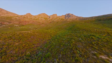 toma aérea de bosques vírgenes, colinas y montañas contra un cielo azul