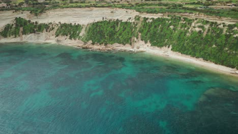 AERIAL:-Ta-Kalanka-Sea-Cave-Bay-with-Majestic-Turquoise-Mediterranean-Sea-and-Greenery-on-Slopes