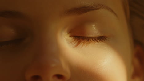 close-up of a person's closed eyes in warm light