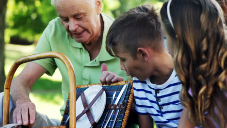 Family-looking-at-wicker-basket-in-the-park