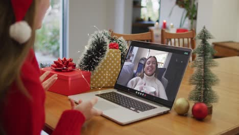 Happy-caucasian-woman-on-video-call-with-female-friend-at-christmas-time