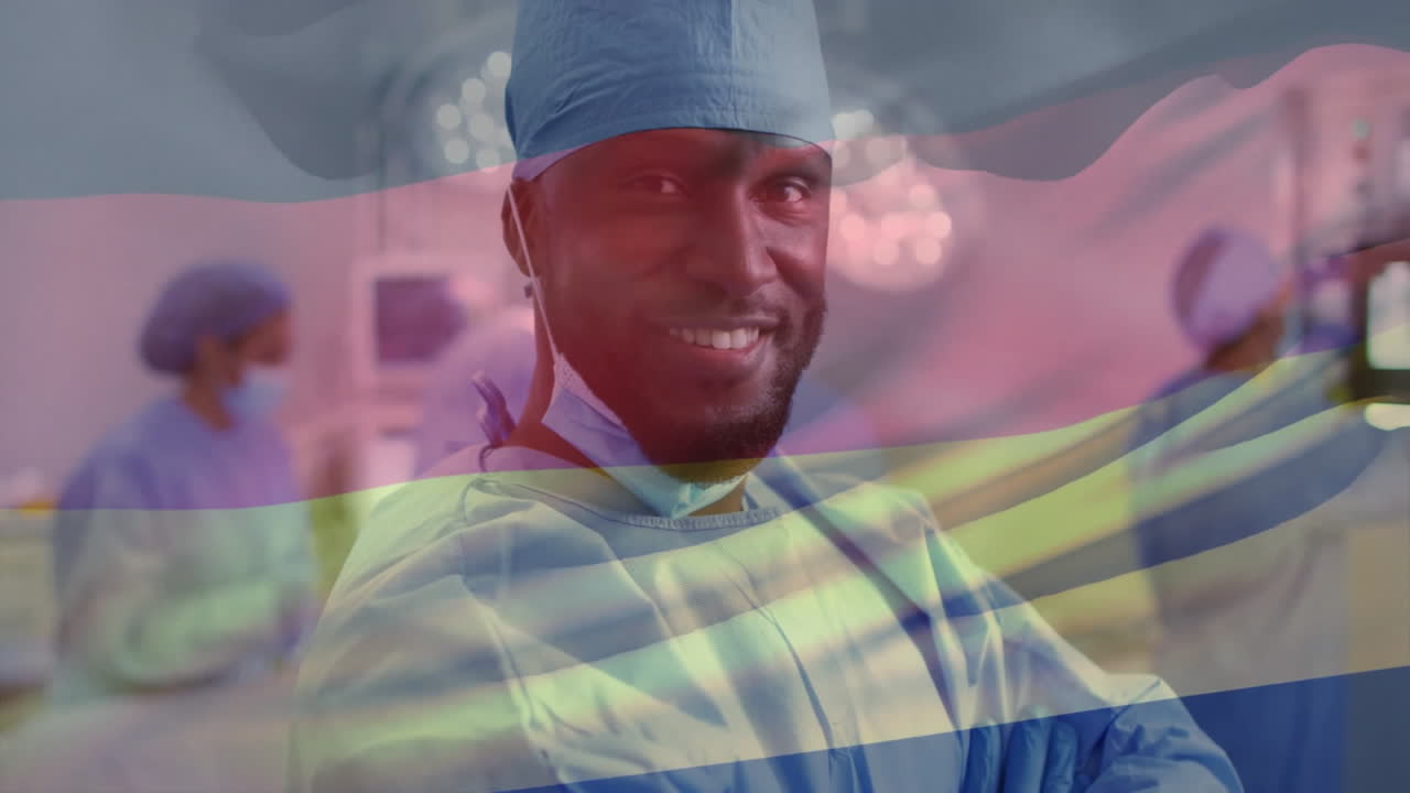 Animation of flag of germany over african american male surgeon in hospital