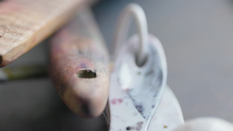 small paint-stained spoons and art supplies on a table