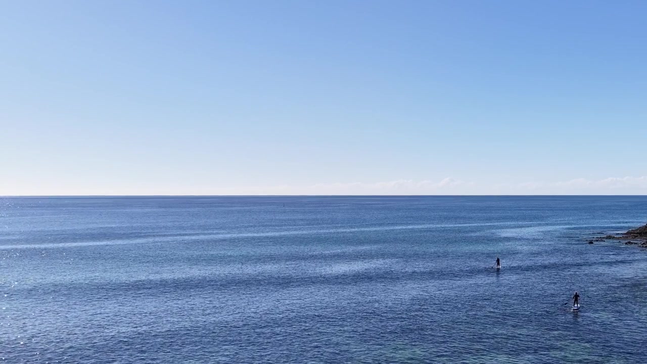 Ampia inquadratura di paddleboarder su acqua calma e turchese a Crescent Head, Nuovo Galles del Sud