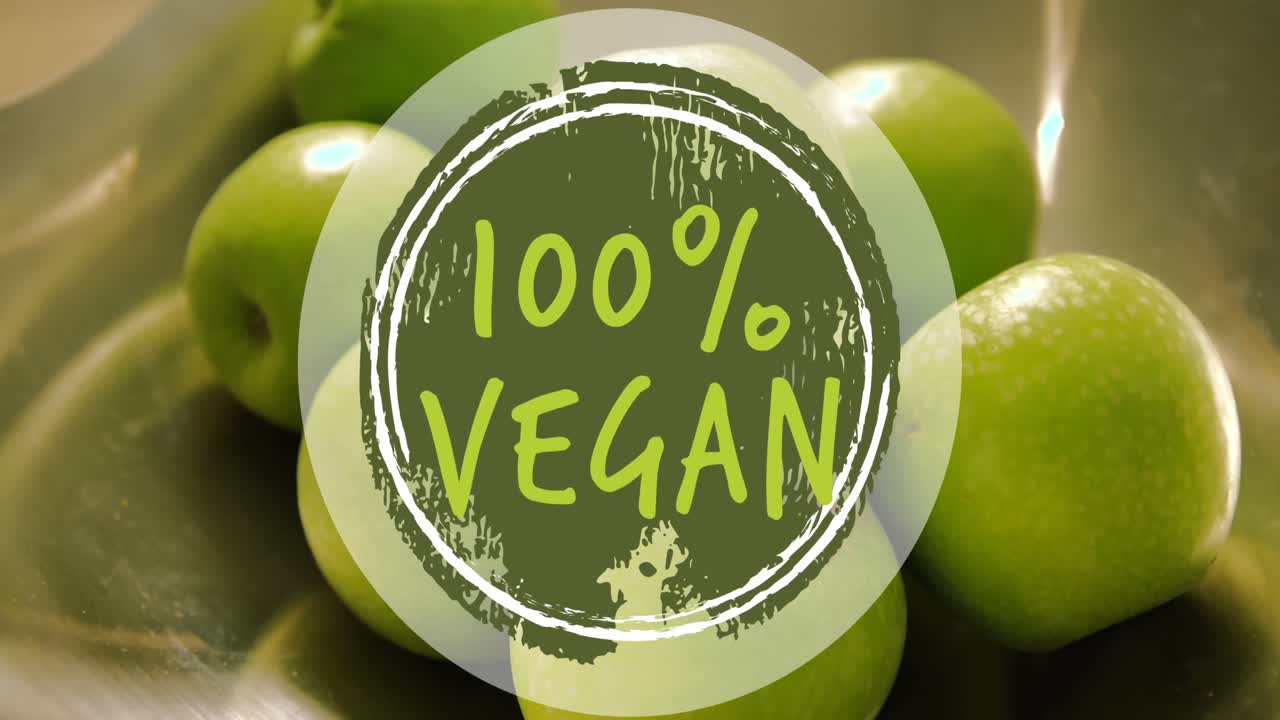 Animação de banner de texto 100% vegano contra close-up de maçãs verdes