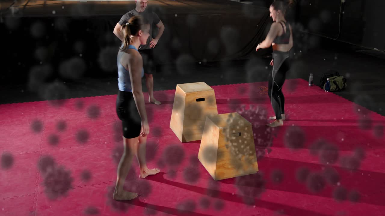 Trainees starting on coach cue performing burpees, box jumps for fitness, speckled overlaying scene