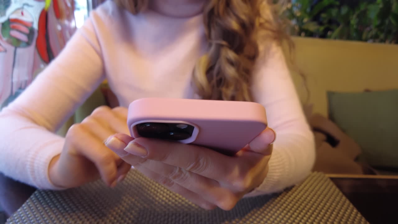 Blonde woman scrolling on her phone at a cafe