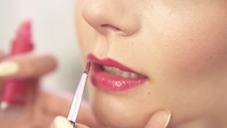 Visagistin,-Die-Mit-Einem-Pinsel-Rosafarbenen-Lippenstift-Aufträgt.-Nahaufnahme.-Zeitlupenaufnahme