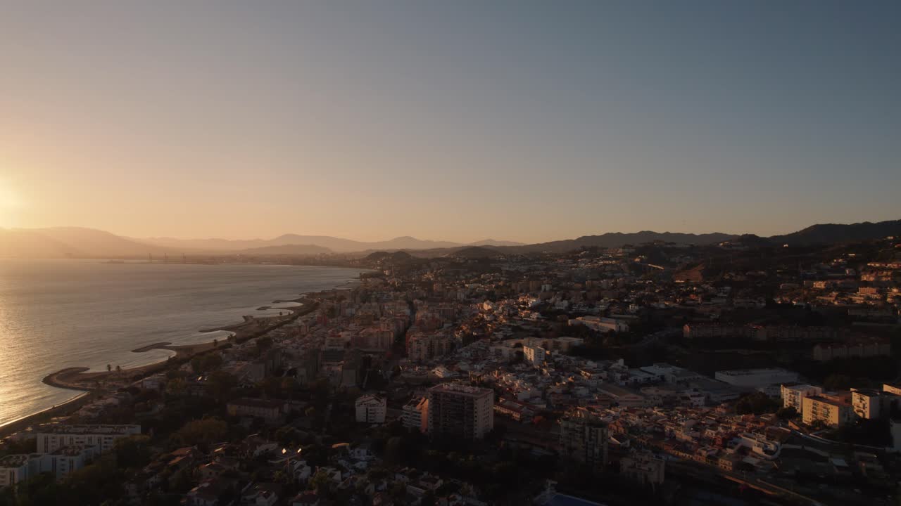 Città con case e appartamenti vicino al mare, scena cinematografica con cielo dorato al tramonto