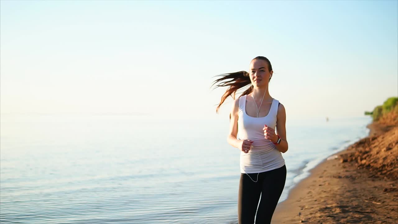 mujer corriendo en la playa al amanecer
