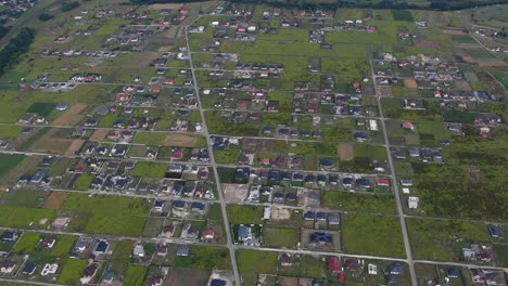 aerial view of eastern europen neighborhood with scattered houses and fields