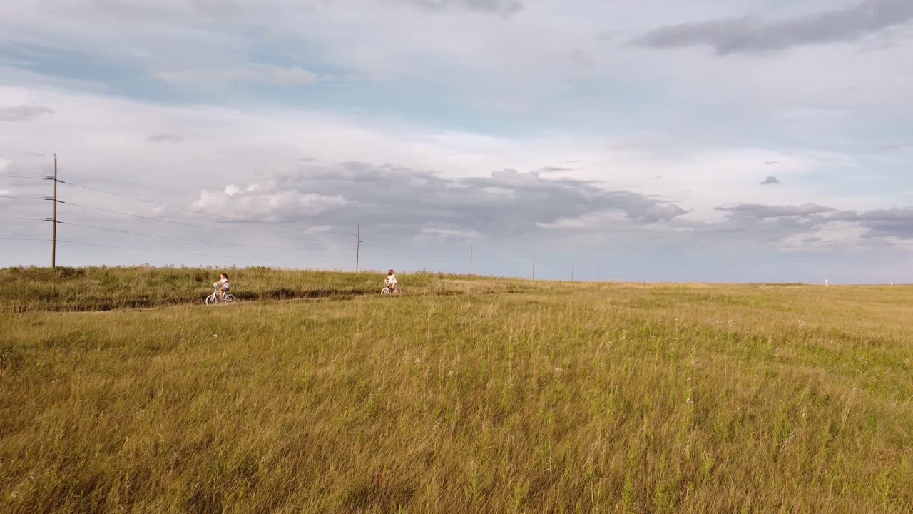 niñas, niños pequeños, montando bicicletas por líneas eléctricas, en el parque nose hill, calgary, alberta, canadá