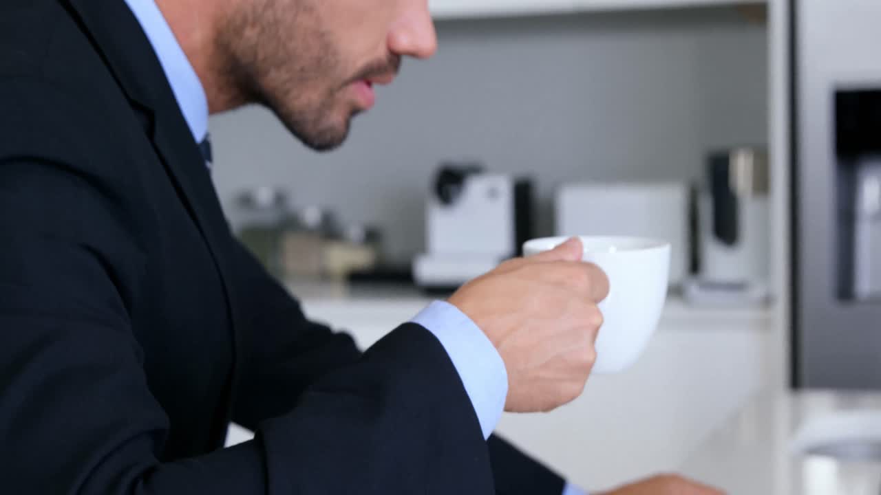 노트북 앞에서 커피를 마시는 사업가