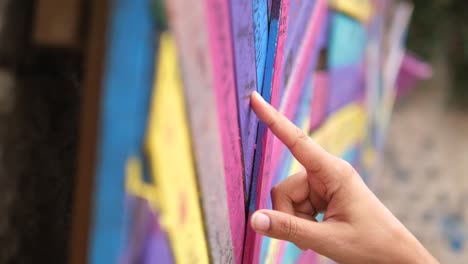 hand pointing at colorful graffiti wall