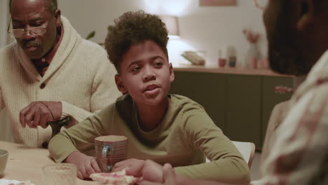 black men and boy eating dinner at home