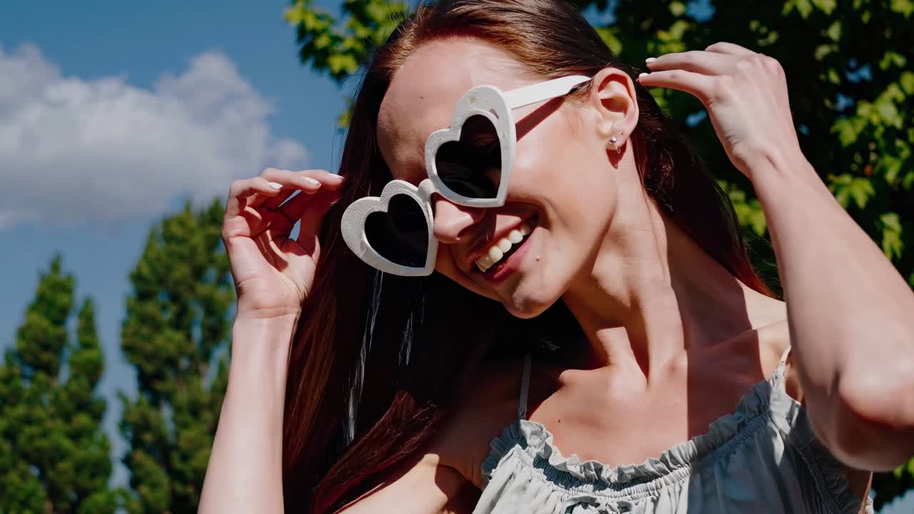 mujer con gafas de sol en forma de corazón al aire libre