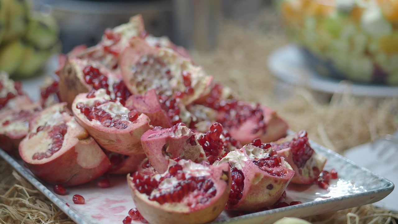 Freshly Cut Pomegranates with Vibrant Red Seeds on a Platter